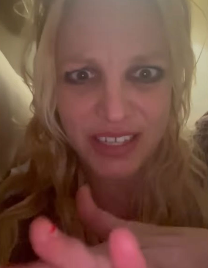 A person with messy hair and chipped nails, looking intensely at the camera.
