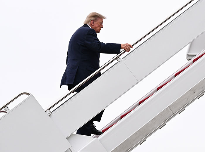 Donald Trump climbs the stairs to Air Force One.